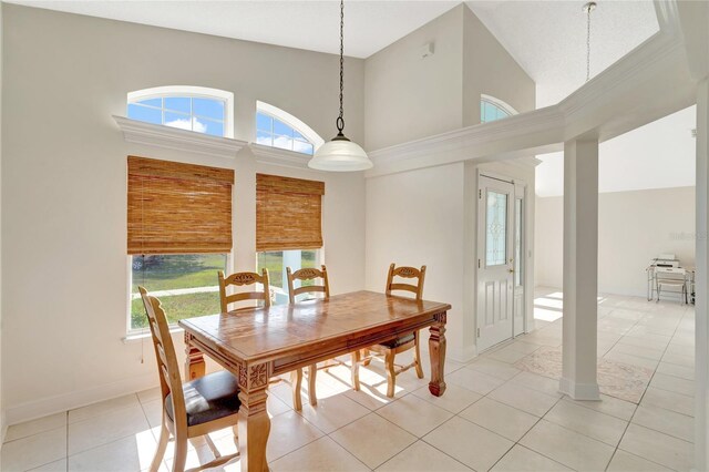 dining space with high vaulted ceiling and light tile patterned flooring