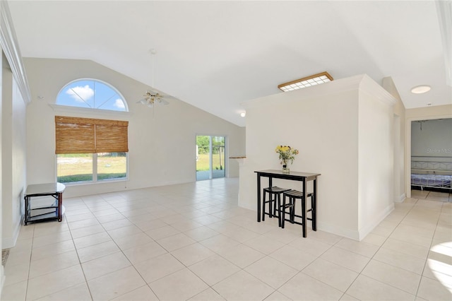 empty room with plenty of natural light, ceiling fan, light tile patterned floors, and high vaulted ceiling