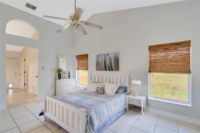 tiled bedroom with multiple windows, ceiling fan, and high vaulted ceiling