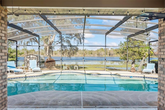 view of swimming pool featuring a lanai, a patio area, and a water view