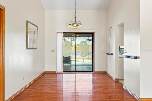 interior space with wood-type flooring and an inviting chandelier