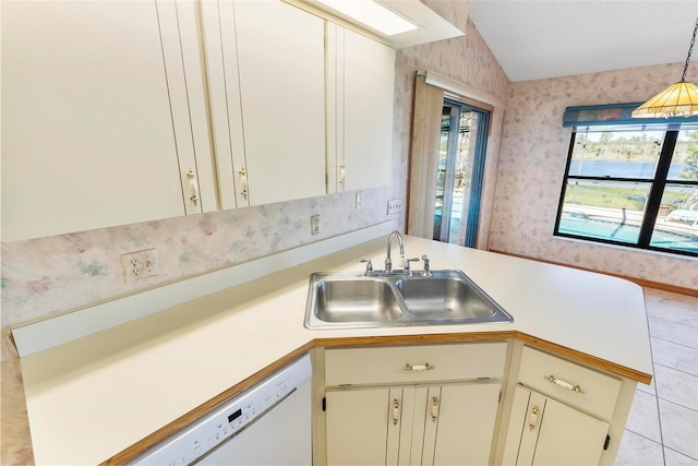 kitchen with sink, hanging light fixtures, white dishwasher, vaulted ceiling, and light tile patterned flooring