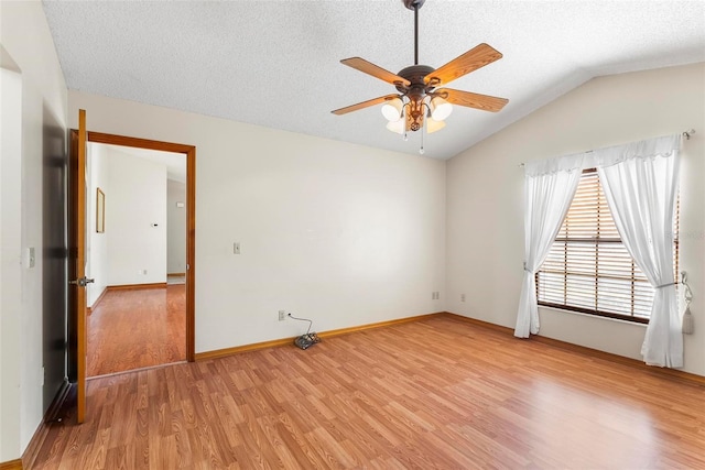 empty room featuring lofted ceiling, ceiling fan, light wood-type flooring, and a textured ceiling