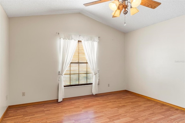 spare room featuring ceiling fan, vaulted ceiling, a textured ceiling, and light hardwood / wood-style flooring