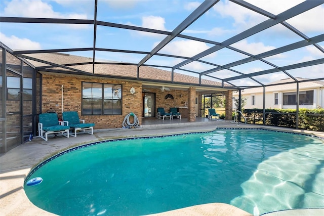 view of swimming pool with glass enclosure and a patio