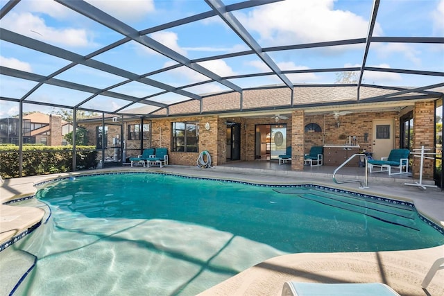 view of pool featuring glass enclosure, a patio area, and ceiling fan