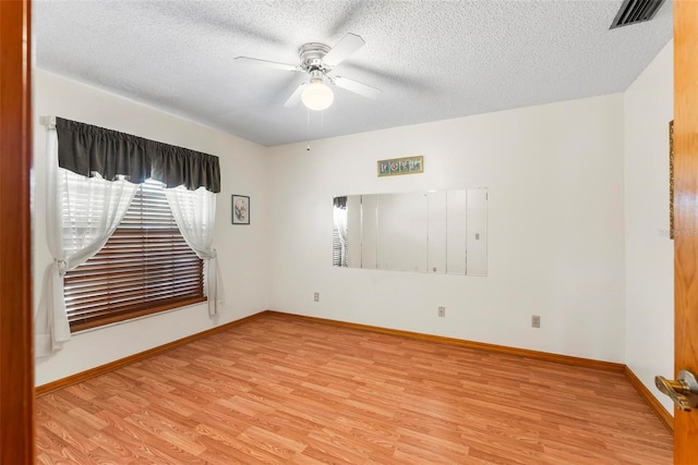 empty room with ceiling fan, a textured ceiling, and light hardwood / wood-style flooring