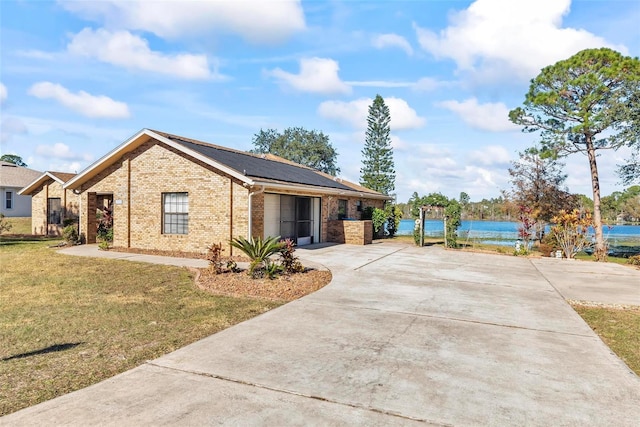 view of front of property with a water view and a front lawn