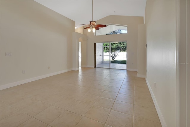 empty room with high vaulted ceiling, ceiling fan, and light tile patterned flooring