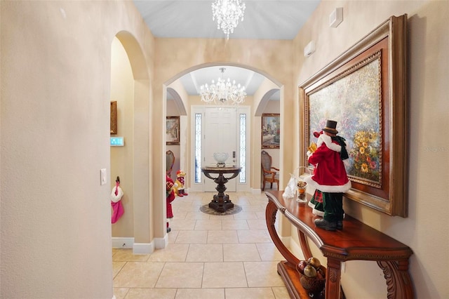 hallway with a chandelier and light tile patterned flooring