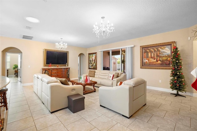 living room with light tile patterned floors, a chandelier, and a textured ceiling