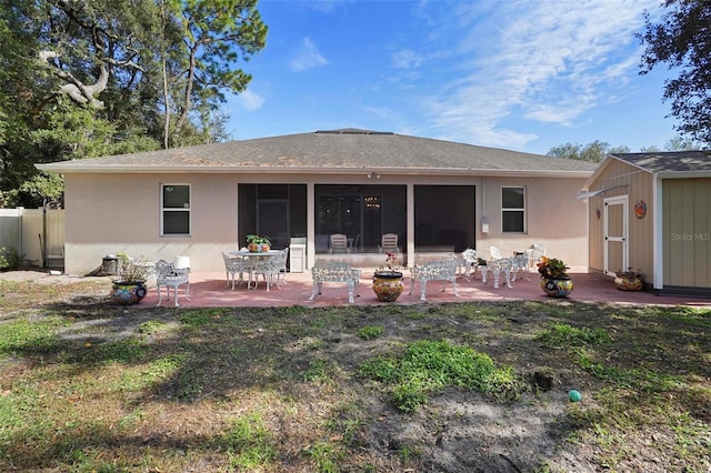 back of house with a patio and a storage shed