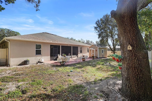 rear view of property with a lawn, a patio area, and an outdoor structure