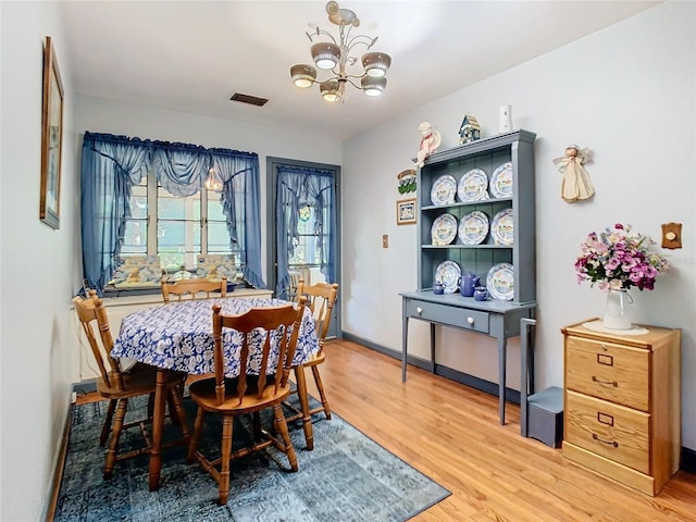 dining room featuring hardwood / wood-style floors and an inviting chandelier