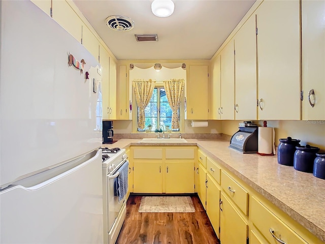 kitchen featuring dark hardwood / wood-style floors, white appliances, and sink