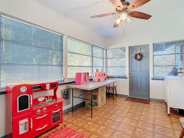 sunroom with heating unit and ceiling fan