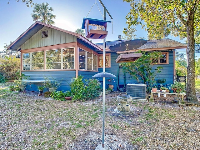 view of front of house with central air condition unit and a sunroom