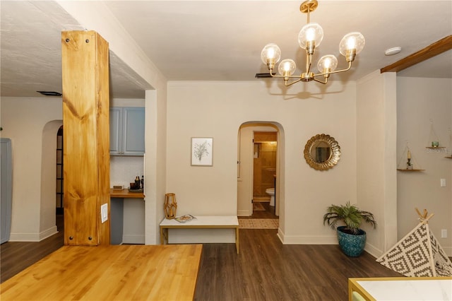 interior space with crown molding, dark wood-type flooring, and a notable chandelier