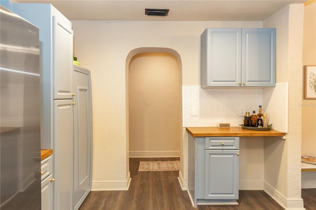 kitchen featuring wood counters, tasteful backsplash, gray cabinets, stainless steel refrigerator, and dark hardwood / wood-style floors