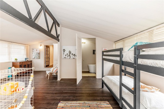 bedroom featuring dark wood-type flooring, lofted ceiling, and ensuite bathroom