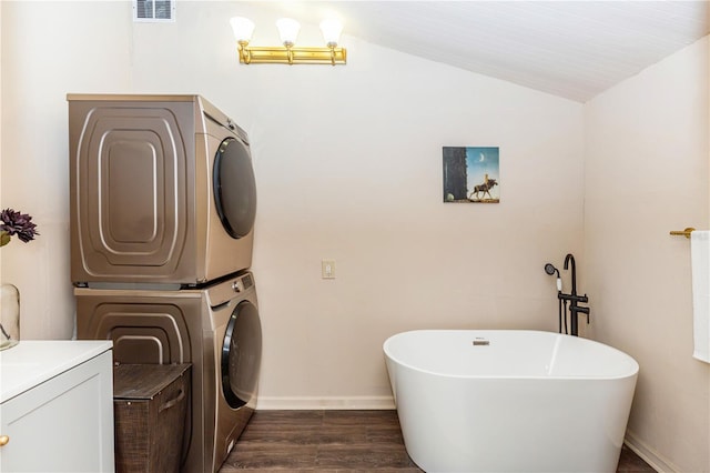 laundry room with dark hardwood / wood-style floors and stacked washer / dryer