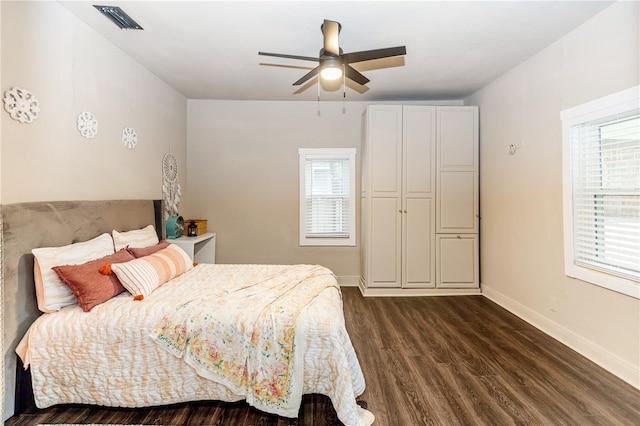 bedroom with multiple windows, ceiling fan, and dark hardwood / wood-style floors