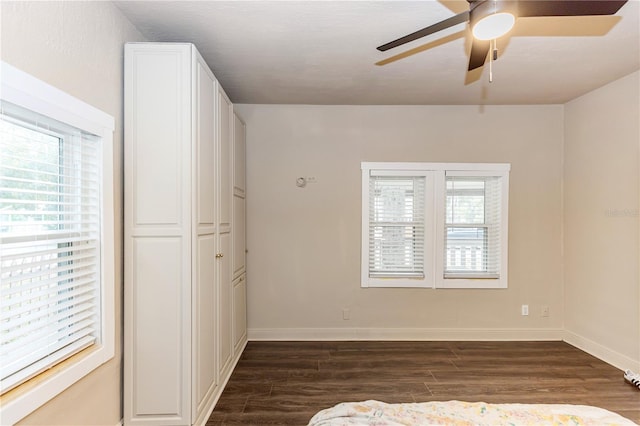 unfurnished bedroom featuring a closet, ceiling fan, and dark hardwood / wood-style flooring