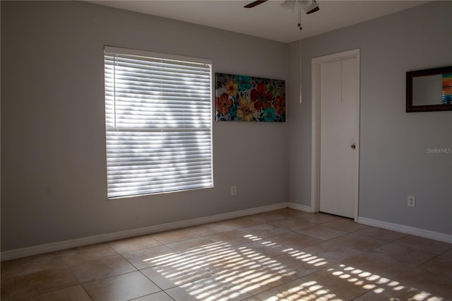 tiled empty room featuring ceiling fan