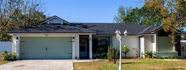 single story home with a garage and a front lawn