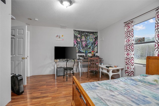 bedroom featuring hardwood / wood-style floors and a textured ceiling