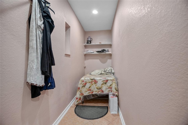 walk in closet with light tile patterned floors