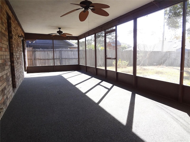 unfurnished sunroom featuring ceiling fan