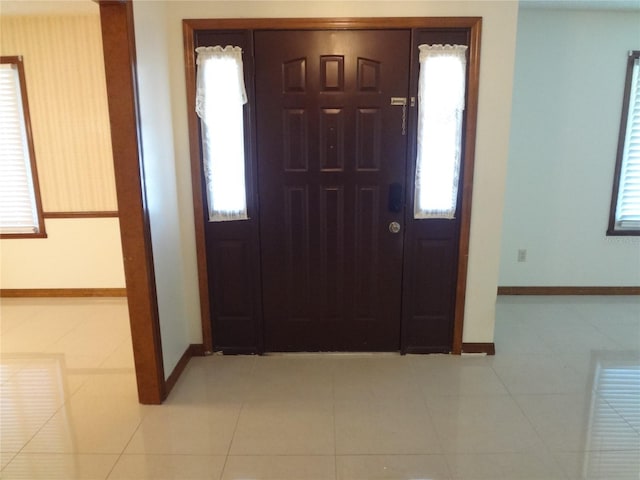 entrance foyer with baseboards and tile patterned flooring