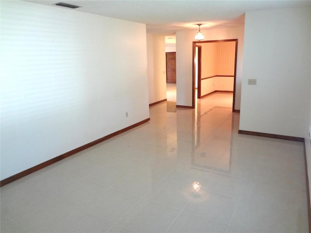 unfurnished room with light tile patterned floors, baseboards, and visible vents