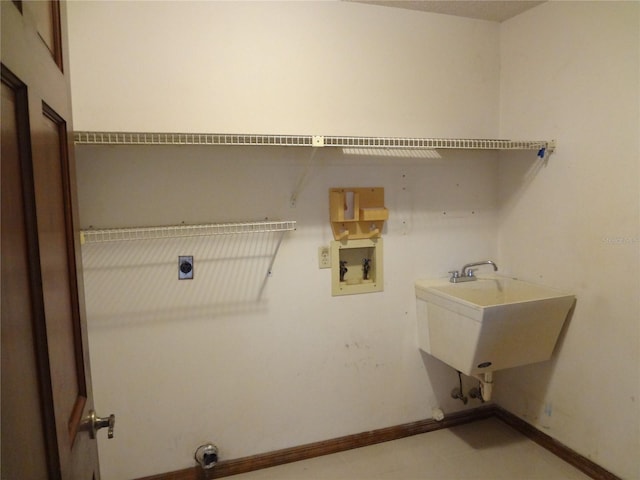 clothes washing area featuring baseboards, hookup for an electric dryer, laundry area, a sink, and washer hookup