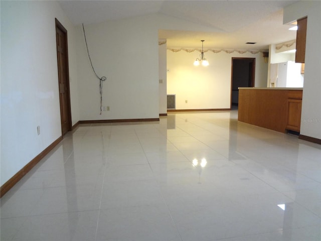 empty room featuring vaulted ceiling, baseboards, and a chandelier