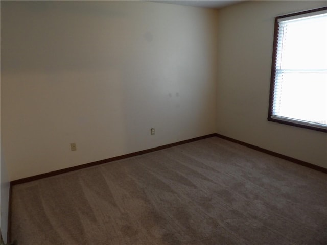 empty room featuring baseboards and carpet floors