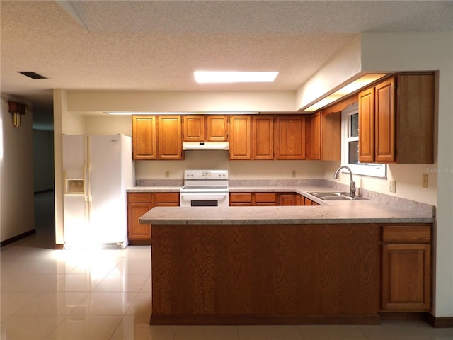 kitchen with white appliances, visible vents, a sink, under cabinet range hood, and brown cabinets