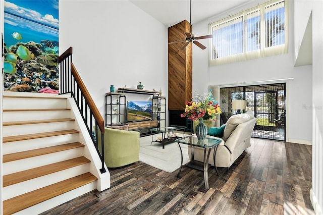 living room featuring plenty of natural light, ceiling fan, a towering ceiling, and dark hardwood / wood-style floors