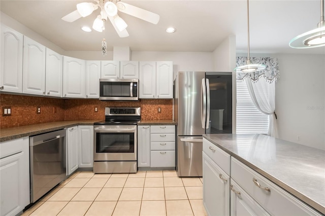 kitchen featuring decorative light fixtures, white cabinetry, and appliances with stainless steel finishes