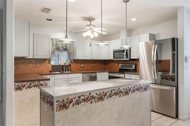 kitchen with backsplash, stainless steel appliances, sink, decorative light fixtures, and white cabinets