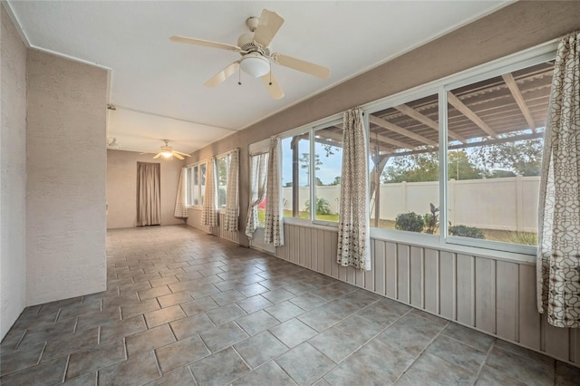 unfurnished sunroom featuring ceiling fan