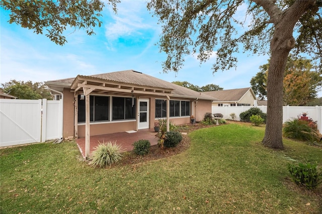 rear view of house with a yard and a patio area