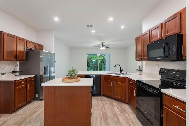 kitchen featuring kitchen peninsula, sink, black appliances, and light hardwood / wood-style flooring