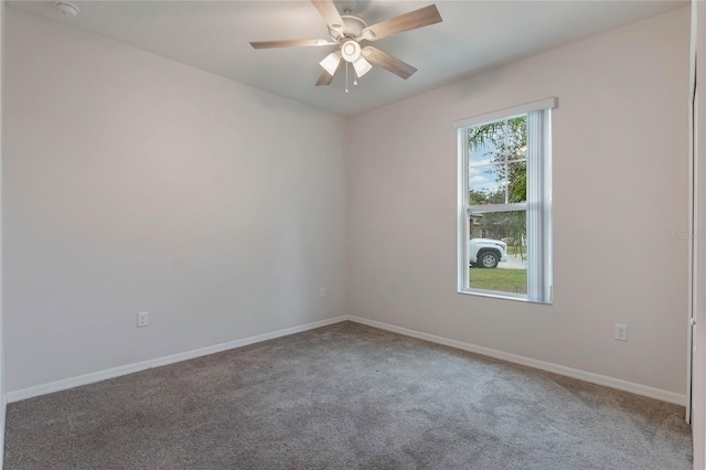 carpeted empty room with baseboards and a ceiling fan