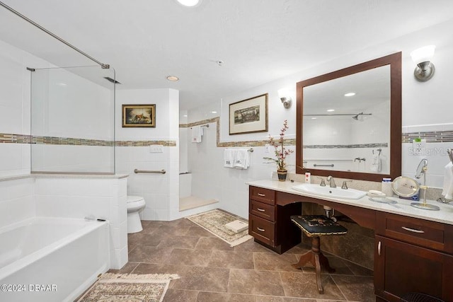 full bathroom with tile patterned floors, vanity, tile walls, plus walk in shower, and toilet