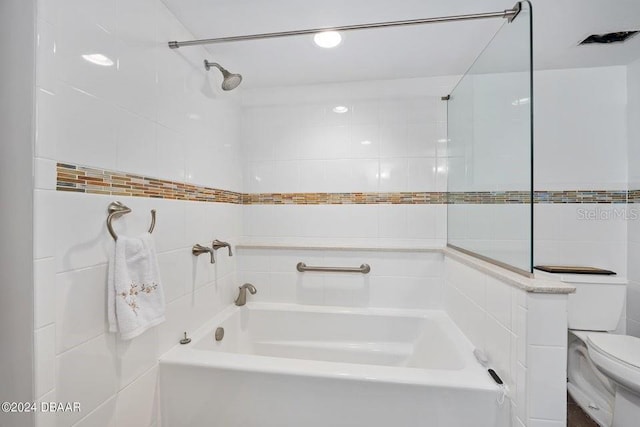 bathroom featuring tile walls and toilet