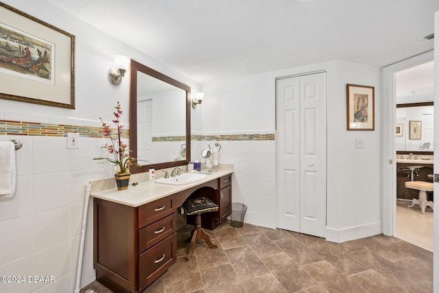 bathroom with vanity and tile walls