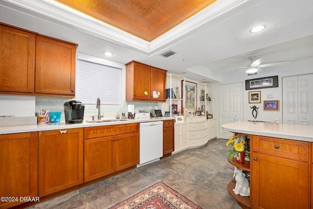 kitchen with ceiling fan, sink, tasteful backsplash, white dishwasher, and a tray ceiling