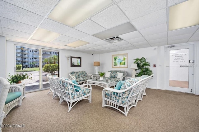 carpeted living room featuring a paneled ceiling